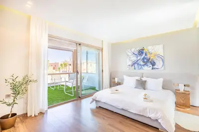 a bedroom with a large white bed and a large window at Villa Zineb Confort, design et sérénité in Marrakech