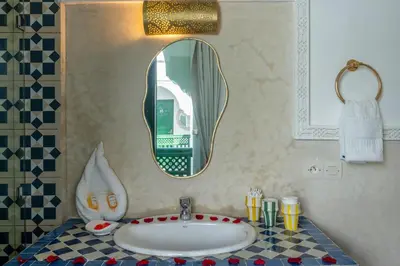 a bathroom with a sink and a mirror at Riad les palmiers de la medina in Marrakech