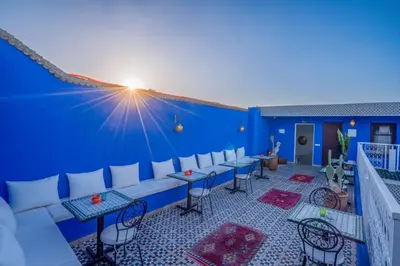 a blue wall with tables and chairs on a balcony at Riad les palmiers de la medina in Marrakech
