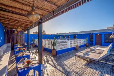 an outdoor patio with blue walls and blue tables at Riad les palmiers de la medina in Marrakech