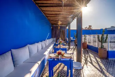 a blue walled room with blue tables and couches at Riad les palmiers de la medina in Marrakech