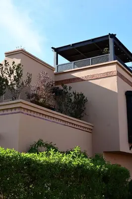 a building with a balcony on top of it at Votre Villa Soleil et Chaleureuse in Marrakech