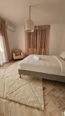 a bedroom with a large bed and a rug at Votre Villa Soleil et Chaleureuse in Marrakech