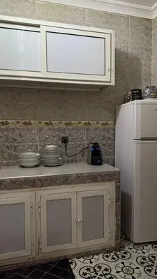 a kitchen with a counter and a white refrigerator at traditional apartment in Marrakech