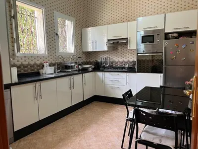 a kitchen with white cabinets and a table in it at Villa in Marrakesh Targa with swimmingpool in Marrakech