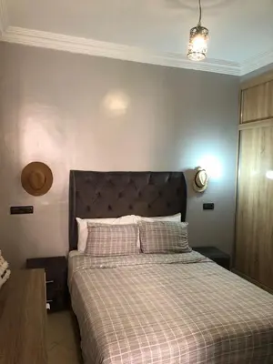 a bedroom with a bed with a checkered blanket at Appartement hay mabroka in Marrakech