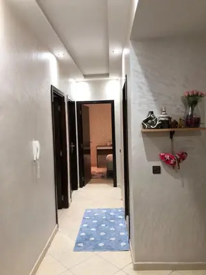 a hallway with a blue rug in a room at Appartement hay mabroka in Marrakech