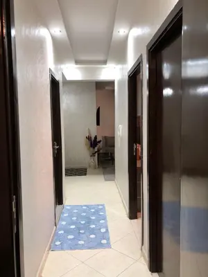 a hallway with a blue rug on the floor at Appartement hay mabroka in Marrakech