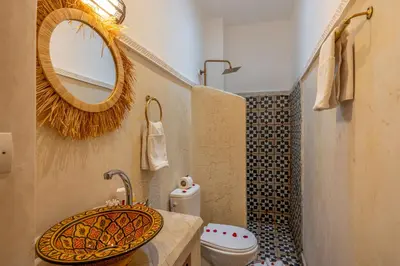 a bathroom with a sink and a toilet and a mirror at Riad Jowara in Marrakech
