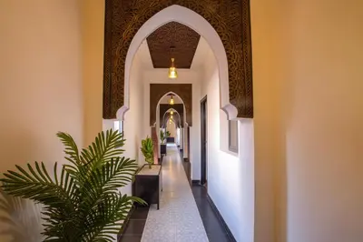 an aisle in a mosque with a palm tree in the middle at Auberge Prince in Marrakech