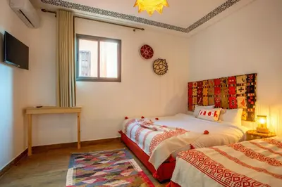 a bedroom with two beds and a window at Auberge Prince in Marrakech