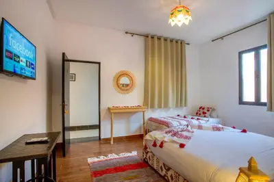 a bedroom with a bed and a television and a table at Auberge Prince in Marrakech