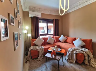a living room with an orange couch and a table at Appartement cosy au cœur de la medina in Marrakech