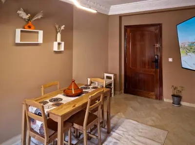 a dining room with a wooden table and chairs at Appartement cosy au cœur de la medina in Marrakech