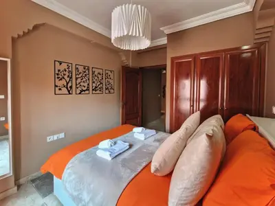 a bedroom with an orange bed with towels on it at Appartement cosy au cœur de la medina in Marrakech