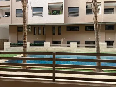 a building with a swimming pool in front of it at Duplex Menara Garden 2 in Marrakech