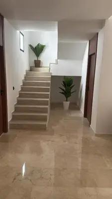 a hallway with stairs and potted plants in a building at Duplex Menara Garden 2 in Marrakech