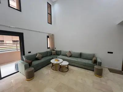 a living room with a green couch and a table at Duplex Menara Garden 2 in Marrakech