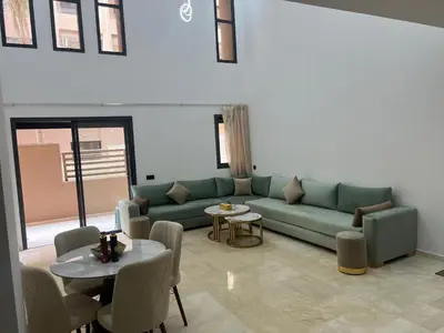 a living room with a green couch and a table at Duplex Menara Garden 2 in Marrakech