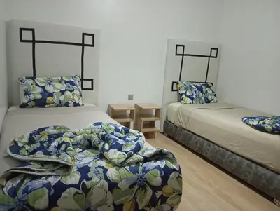 a bedroom with two beds with blue and white sheets at Appartement prestigia golf in Marrakech