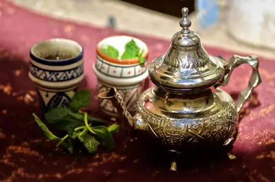 a tea kettle and two cups on a table at Riad Yalulen in Marrakech