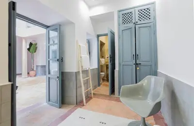 a bathroom with a white chair and a glass door at Riad HØBÖ-CHIC privé Medina rooftop WI-FI Fibre in Marrakech