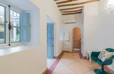 a living room with a green chair and a window at Riad HØBÖ-CHIC privé Medina rooftop WI-FI Fibre in Marrakech