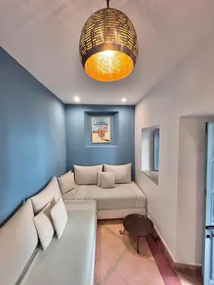 a living room with a couch and a chandelier at Riad HØBÖ-CHIC privé Medina rooftop WI-FI Fibre in Marrakech