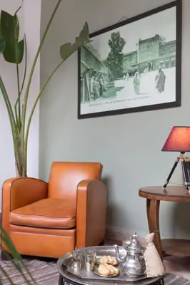 a living room with a chair and a table at Riad HØBÖ-CHIC privé Medina rooftop WI-FI Fibre in Marrakech