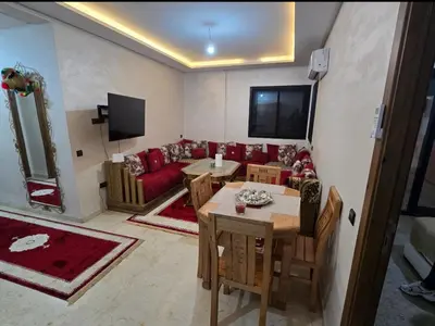 a living room with a red couch and a table at Appartement Gueliz in Marrakech