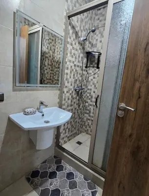 a bathroom with a sink and a shower with a mirror at Appartement Gueliz in Marrakech