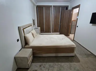 a bedroom with a large bed and a mirror at Appartement Gueliz in Marrakech