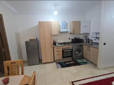 a kitchen with wooden cabinets and a washer and dryer at Appartement Gueliz in Marrakech
