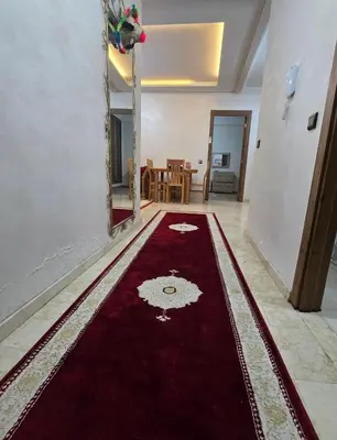 a living room with a red rug on the floor at Appartement Gueliz in Marrakech