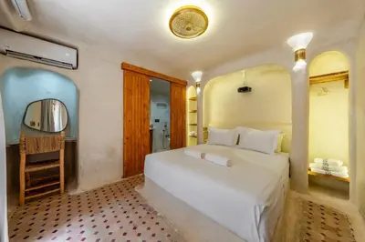 a bedroom with a white bed and a mirror at DarNiama - 3 Suites & Private Pool - Gueliz Center in Marrakech