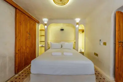 a bedroom with a large white bed with white pillows at DarNiama - 3 Suites & Private Pool - Gueliz Center in Marrakech