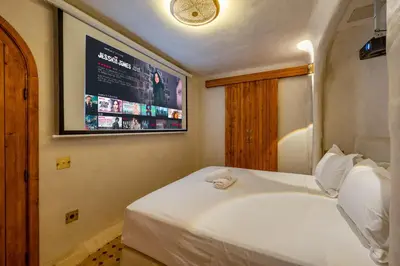 a bedroom with a white bed with a tv on the wall at DarNiama - 3 Suites & Private Pool - Gueliz Center in Marrakech