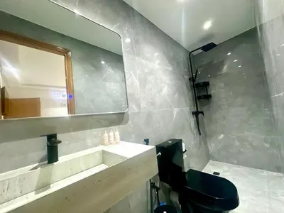 a bathroom with a black toilet and a mirror at Chic duplex luxury3suites et wi-fi in Marrakech