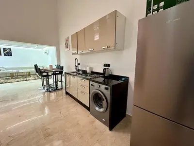 a kitchen with a refrigerator and a washing machine at Chic duplex luxury3suites et wi-fi in Marrakech