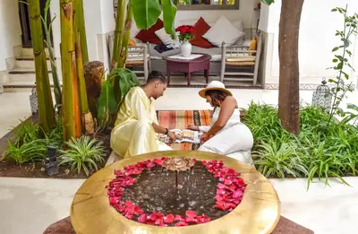 a man and a woman sitting next to a fountain at Riad Dar Aman in Marrakech