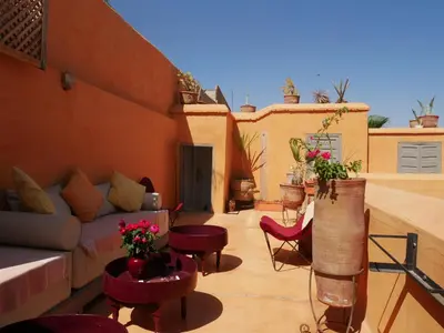 a living room with a couch and chairs on a balcony at Riad Dar Aman in Marrakech