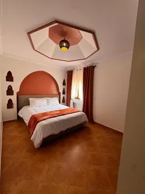 a bedroom with a large bed and a ceiling at Appartement typique Marrakech in Marrakech