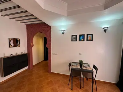a dining room with a table and chairs in a room at Appartement typique Marrakech in Marrakech