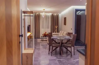 a dining room and living room with a table and chairs at Cocon Stylé & Spacieux au Cœur de Ville in Marrakech