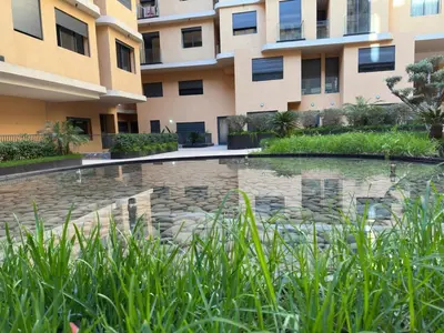 a swimming pool in front of a building at Cocon Stylé & Spacieux au Cœur de Ville in Marrakech
