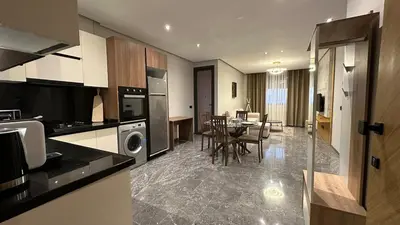 a kitchen and living room with a table and chairs at Le Cocon 28 Spacieux & Stylé au Cœur de la Ville in Marrakech