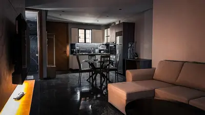 a living room with a couch and a kitchen at Le Cocon 28 Spacieux & Stylé au Cœur de la Ville in Marrakech