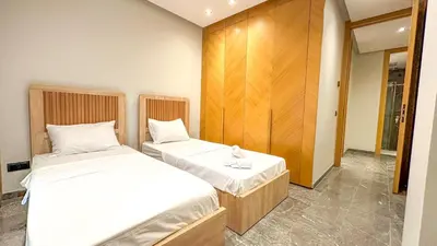 a bedroom with two beds and a wooden wall at Le Cocon 28 Spacieux & Stylé au Cœur de la Ville in Marrakech