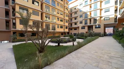 an apartment complex with a courtyard with trees and buildings at Le Cocon 28 Spacieux & Stylé au Cœur de la Ville in Marrakech