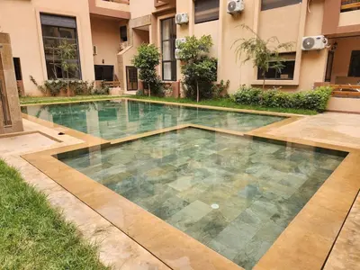a swimming pool in front of a building at Bohemian Chic Apartment in Guéliz - Pool View in Marrakech